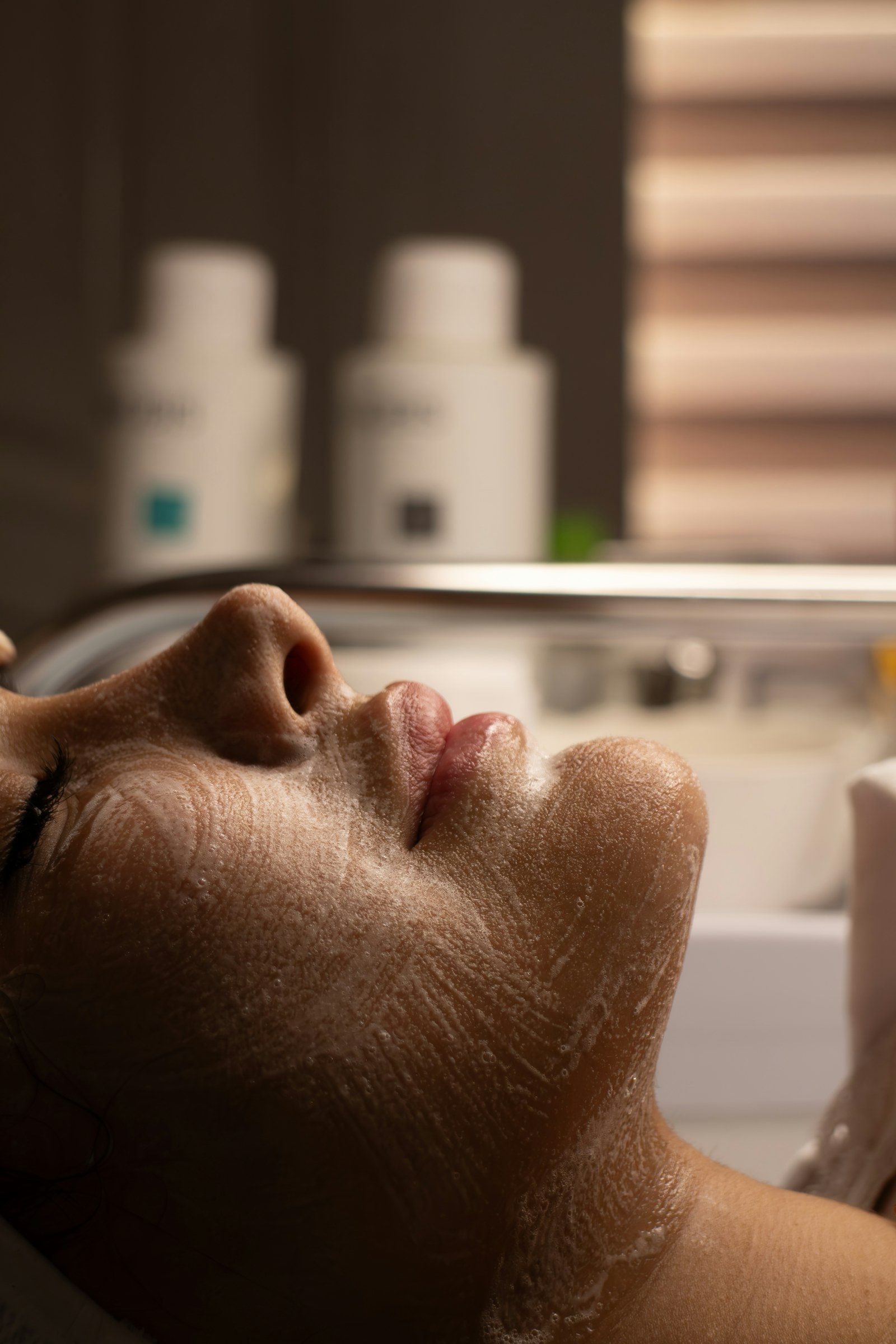 A close-up skincare facial in warm, softly lit surroundings